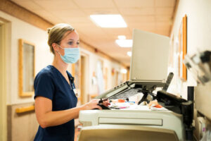 nurse at computer hallway