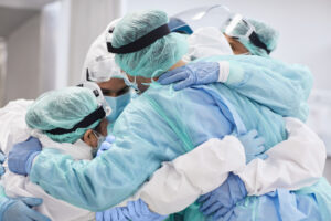 Nurse practitioner in huddle with colleagues