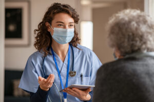 Young nurse practitioner speaking with older adult patient